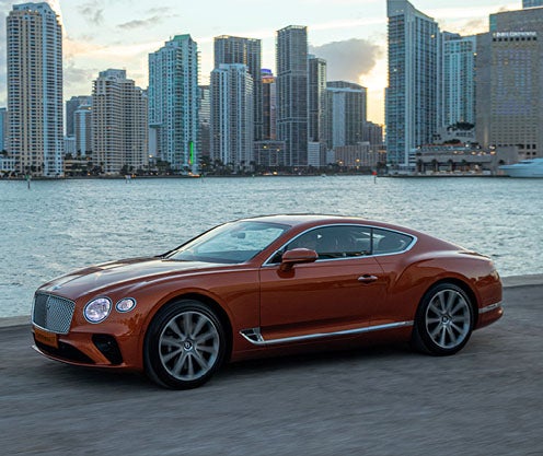 Bentley Contenintal parked outside of city overlooking water