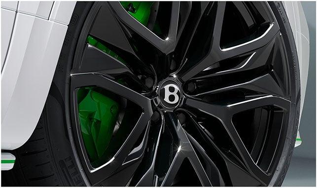 Gloss black alloy wheel with green brake caliper on the 2026 Bentley Bentayga Speed, showcasing performance-focused SUV styling.