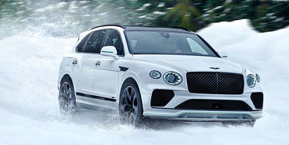 Front three-quarter view of the 2026 Bentley Bentayga Speed navigating snowy terrain, highlighting its dynamic control, power, and seasonal versatility.
