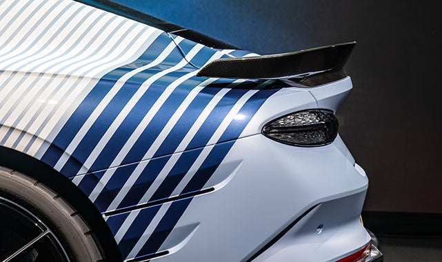 Aerodynamic rear wing and blue-striped vinyl wrap on the tail of the 2026 Bentley Supersports performance coupe.