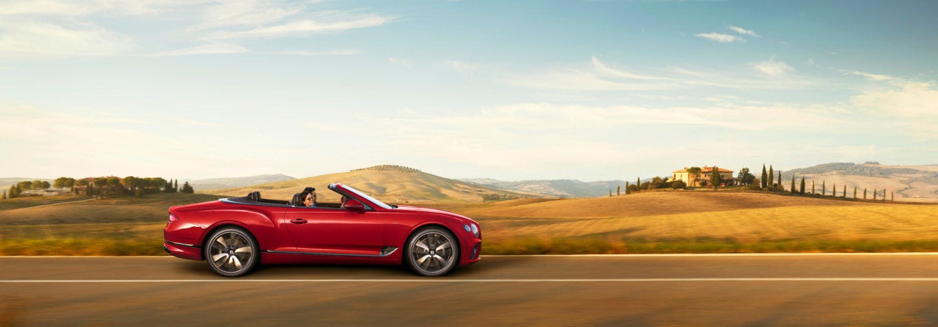 Continental GT Convertible drivingpast-wooded hill italy | Bentley Tampa Bay in Pinellas Park FL